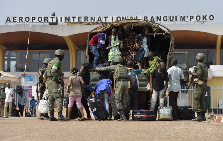 People from the Cameroonese community get off a truck as they arrive at the Bangui International airport on Dec. 29, 2013.